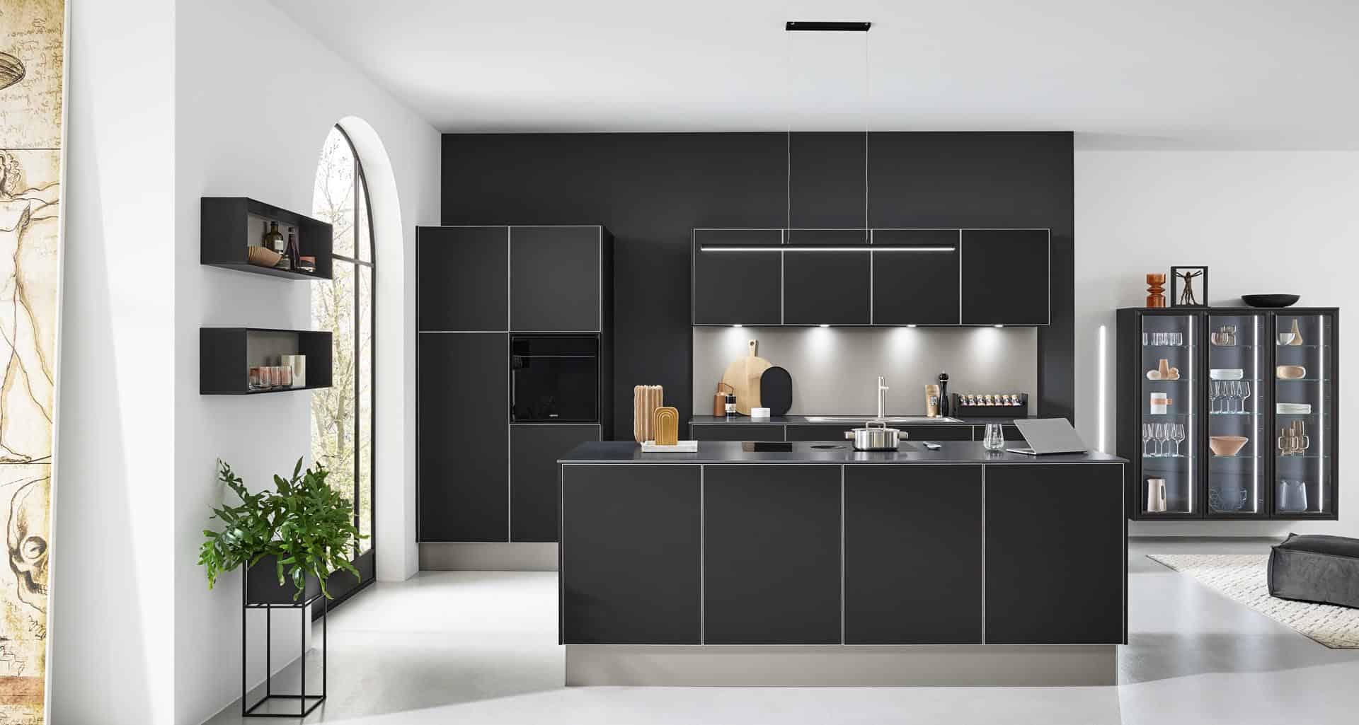 Moderne schwarze Küche mit Insel und Glasvitrine.