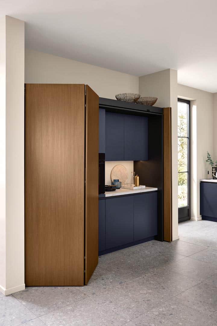 Moderne Küche mit blauen Schränken und Holztüren.