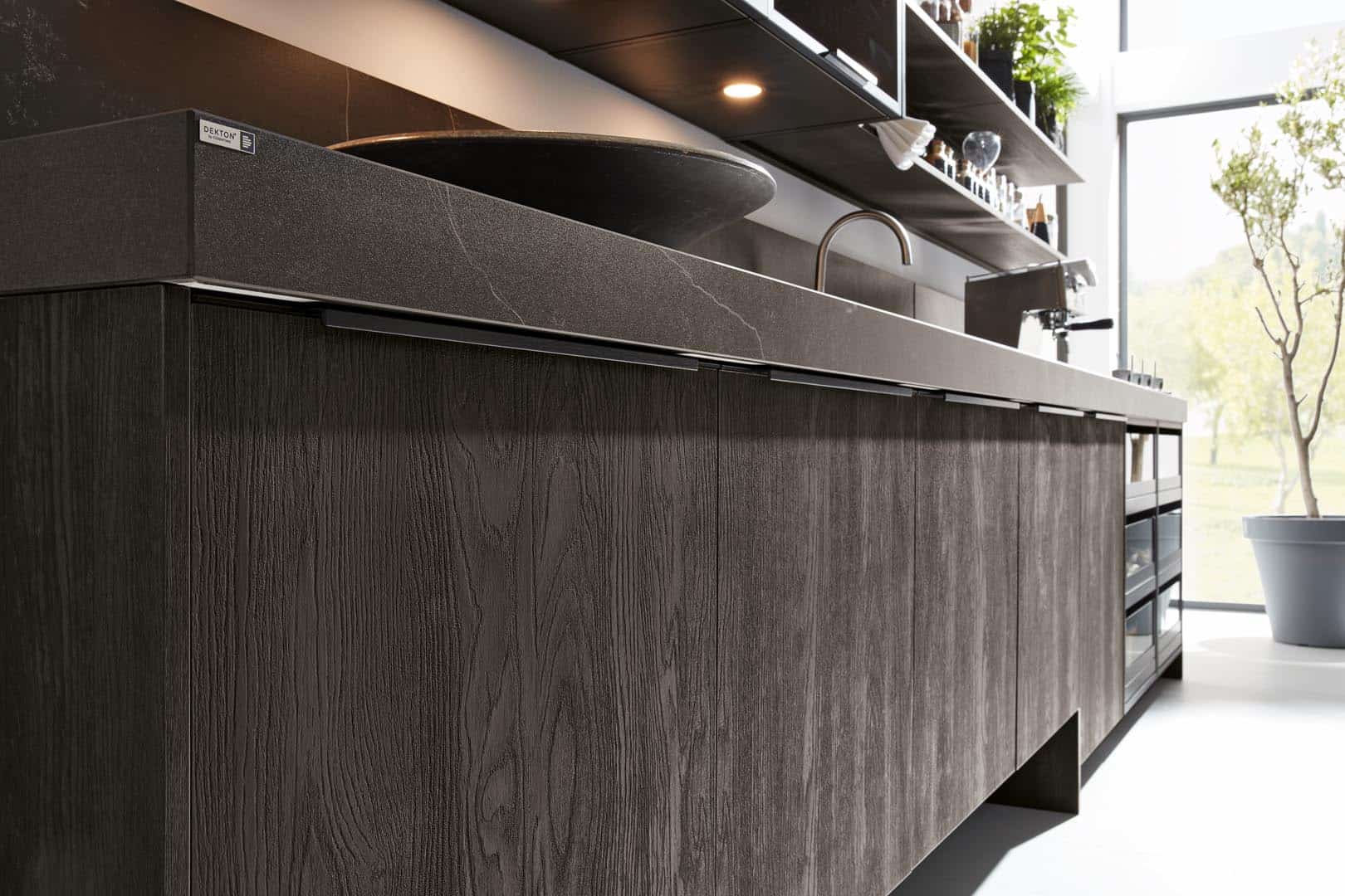 Moderne Küche mit dunkler Holzoberfläche und Dekton-Arbeitsplatte.