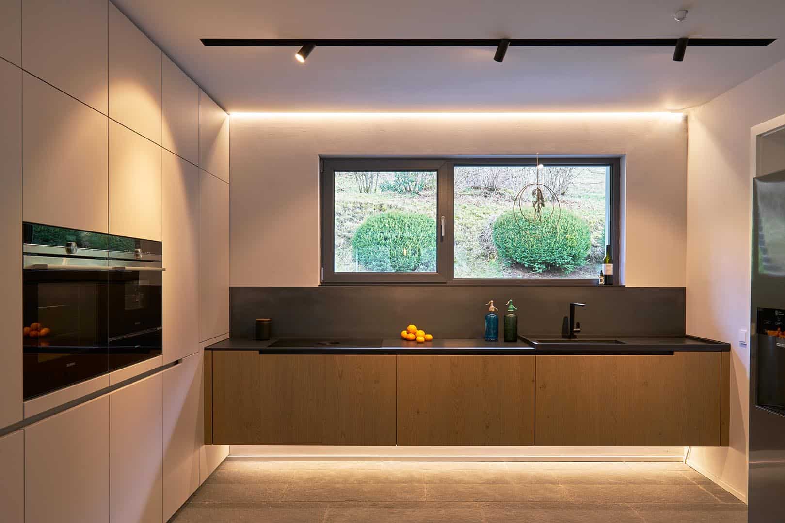 Moderne Küche mit großem Fenster und Beleuchtung