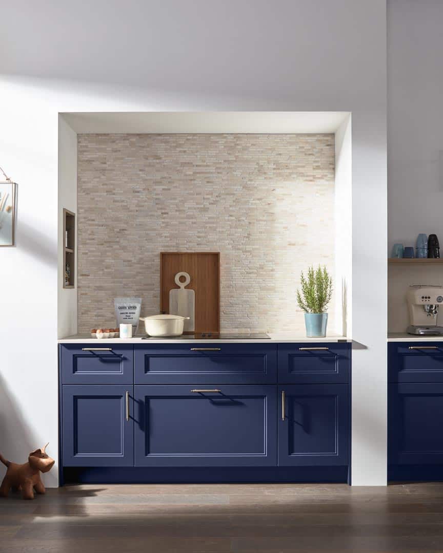 Moderne Küche mit blauen Schränken und Dekorationen.