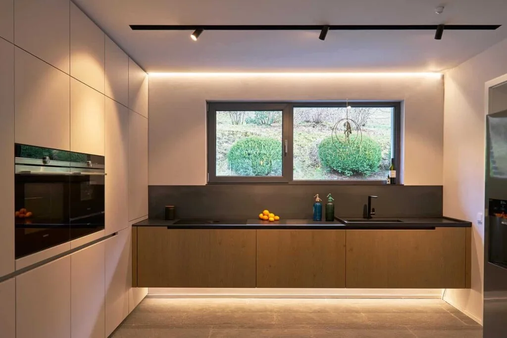 Moderne Küche mit großem Fenster und Beleuchtung