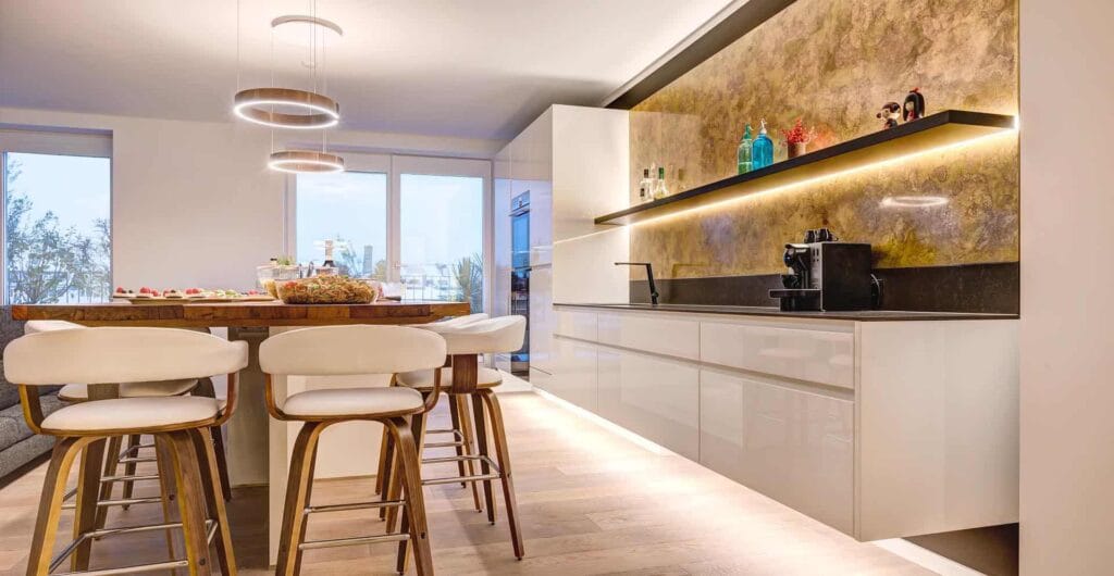 Moderne Küche mit Esstisch und Hängelampen.