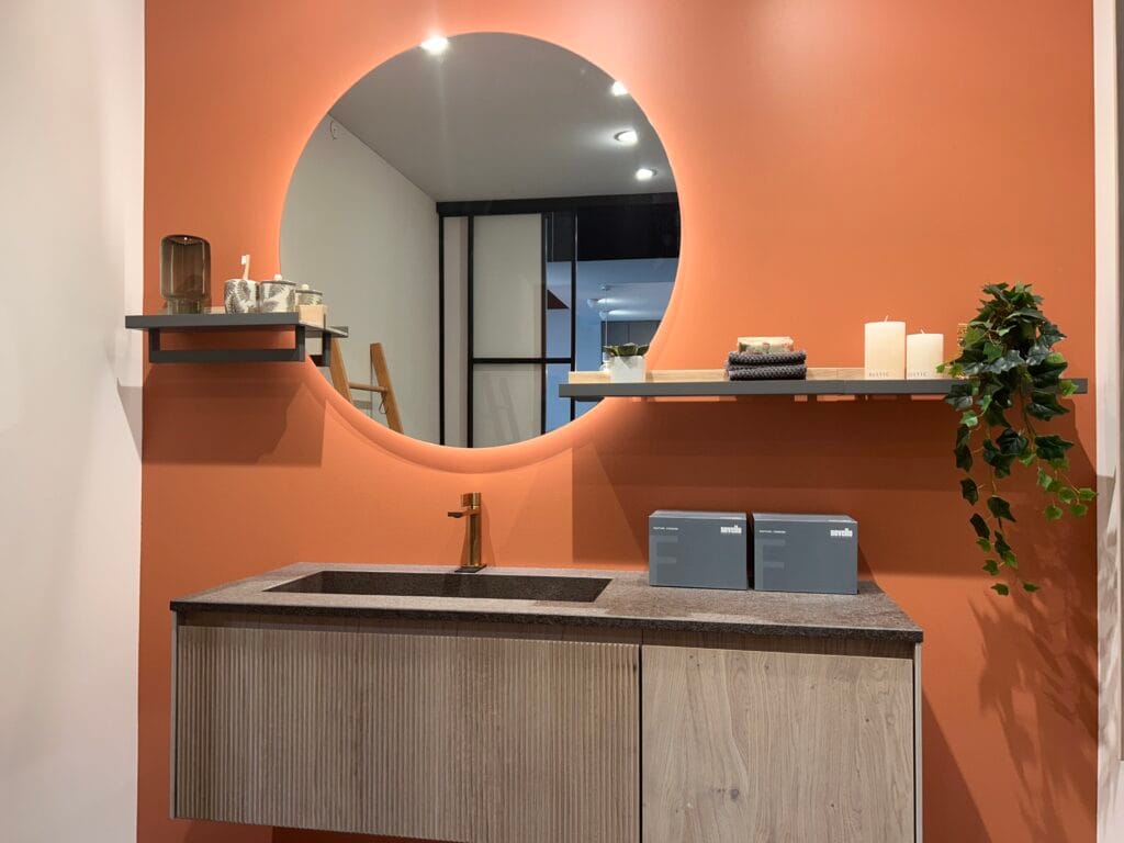 Modernes Badezimmer mit runder Spiegelwand und Pflanzen in Terracotta