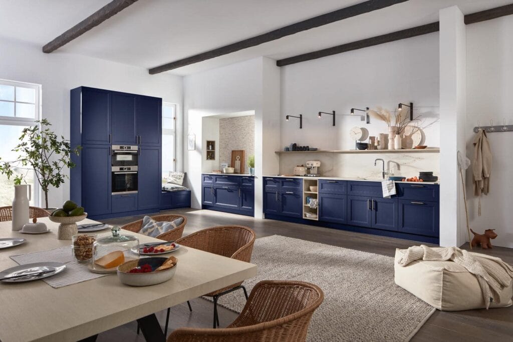 Moderne Küche mit blauen Schränken und Esstisch