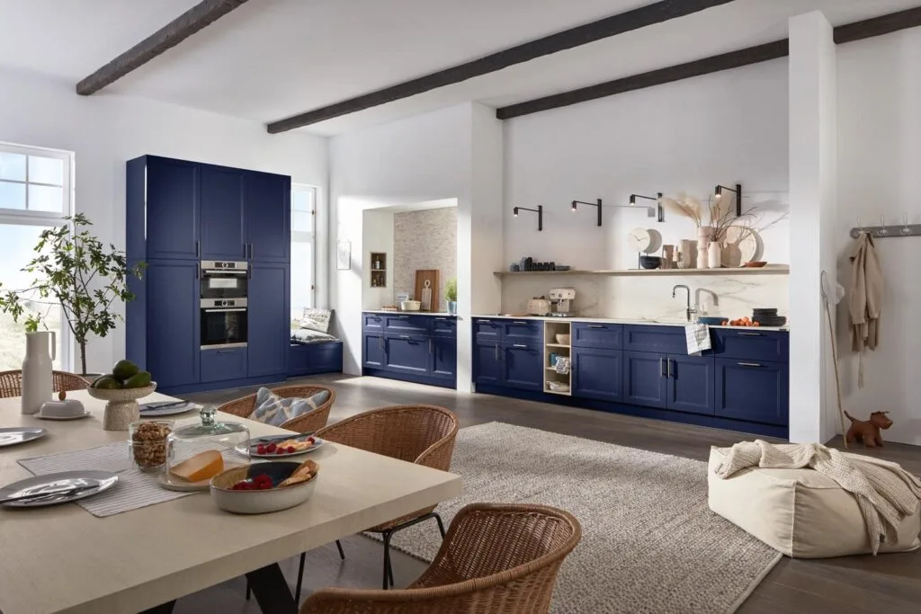 Moderne Küche mit blauen Schränken und Esstisch