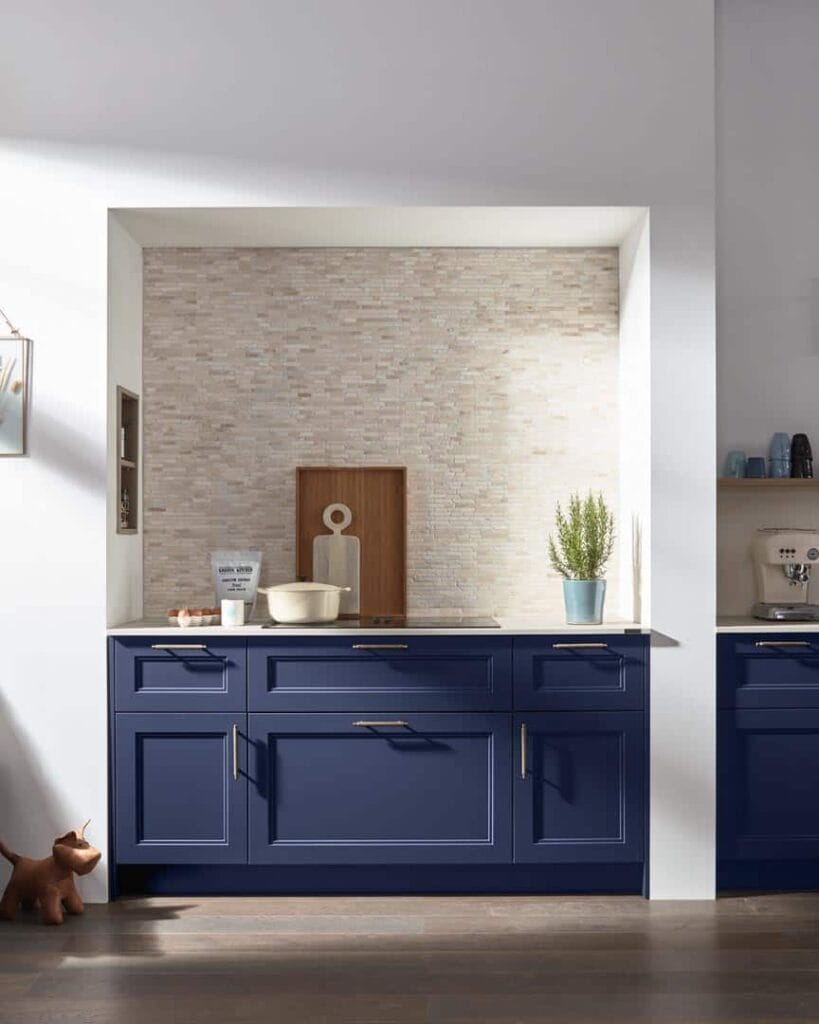 Moderne Küche mit blauen Schränken und Dekorationen.