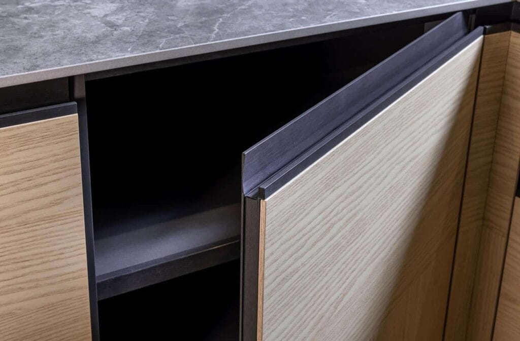 Geöffnete Schranktür mit Holzstruktur und grauer Oberfläche.