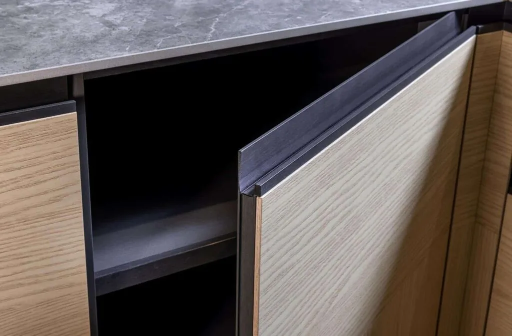 Geöffnete Schranktür mit Holzstruktur und grauer Oberfläche.